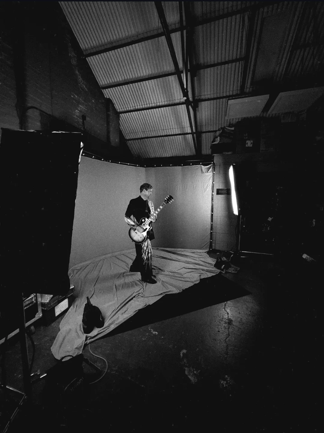 The full lighting setup flanking the backdrop as the guitarist performs