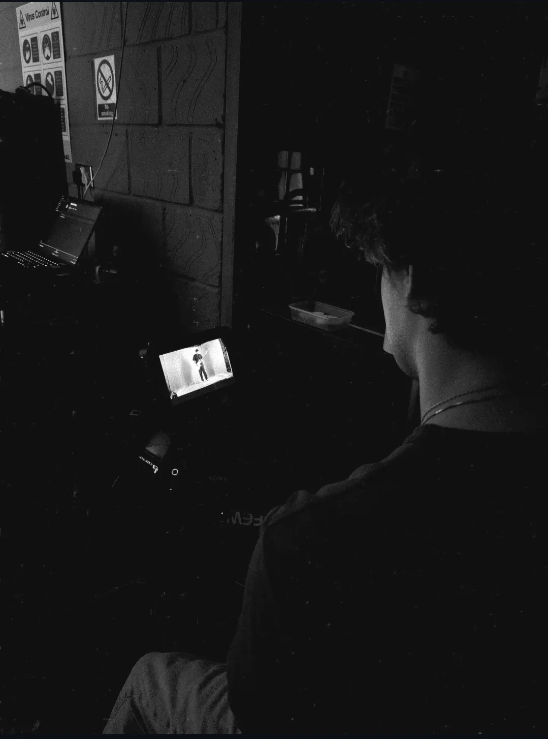 A crew member watching a field monitor from the production area during the shoot