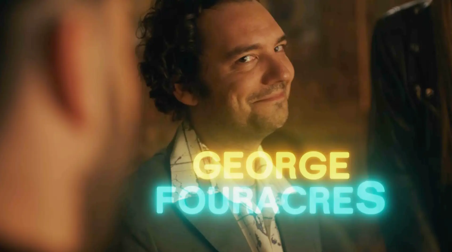 George Fouracres in the SNL UK Series 2 opening titles, with yellow and turquoise neon name graphics